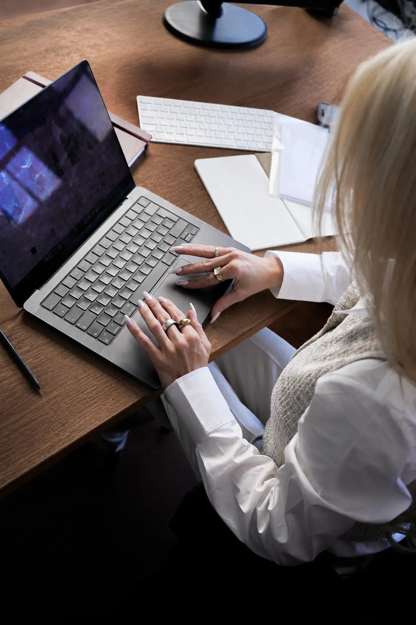 Overhead view of Bianca Da Silva working on her laptop at a desk, planning retail buying and product sourcing strategy